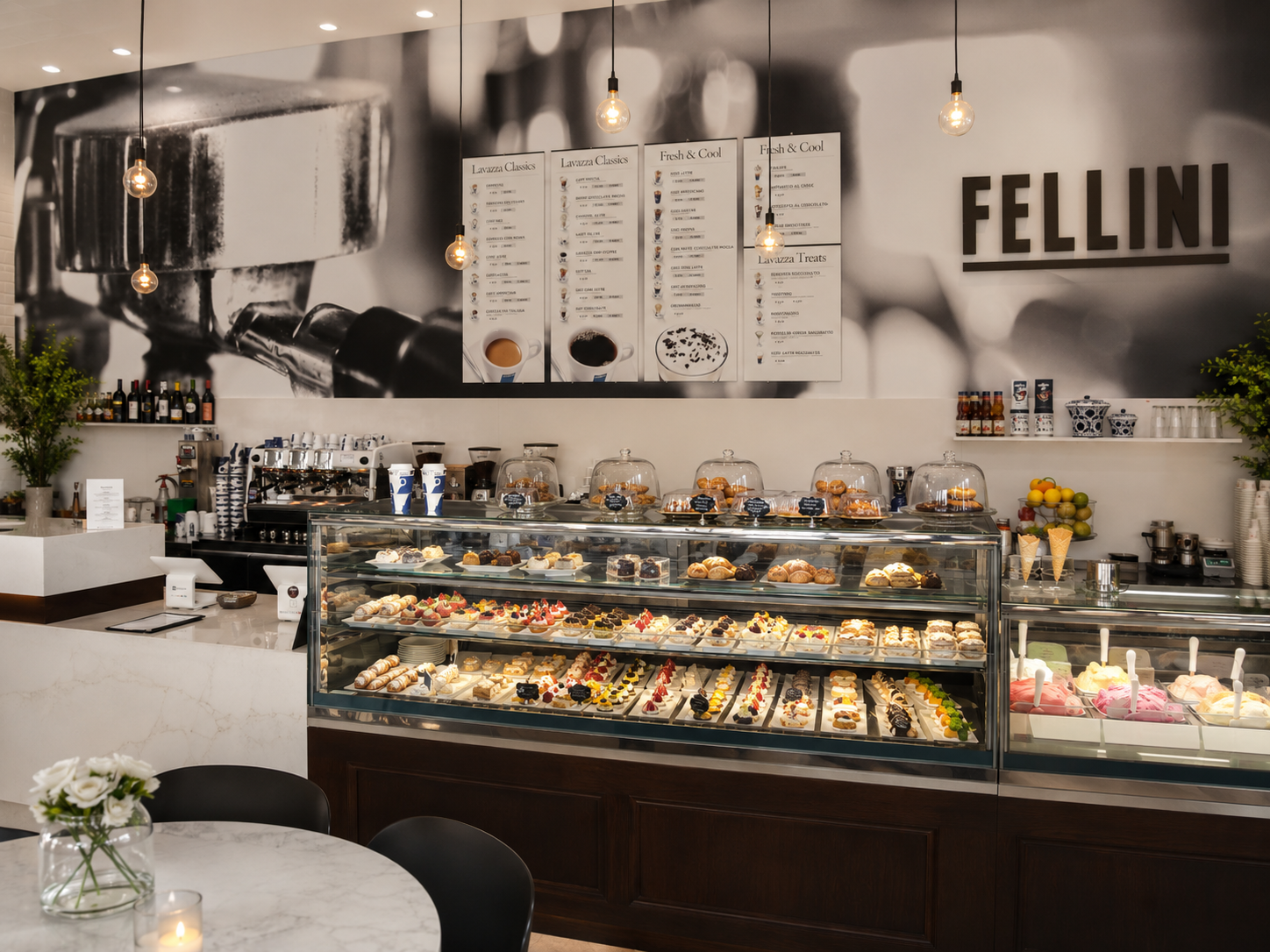 Fellini café interior with coffee menus and a long display case of Italian pastries