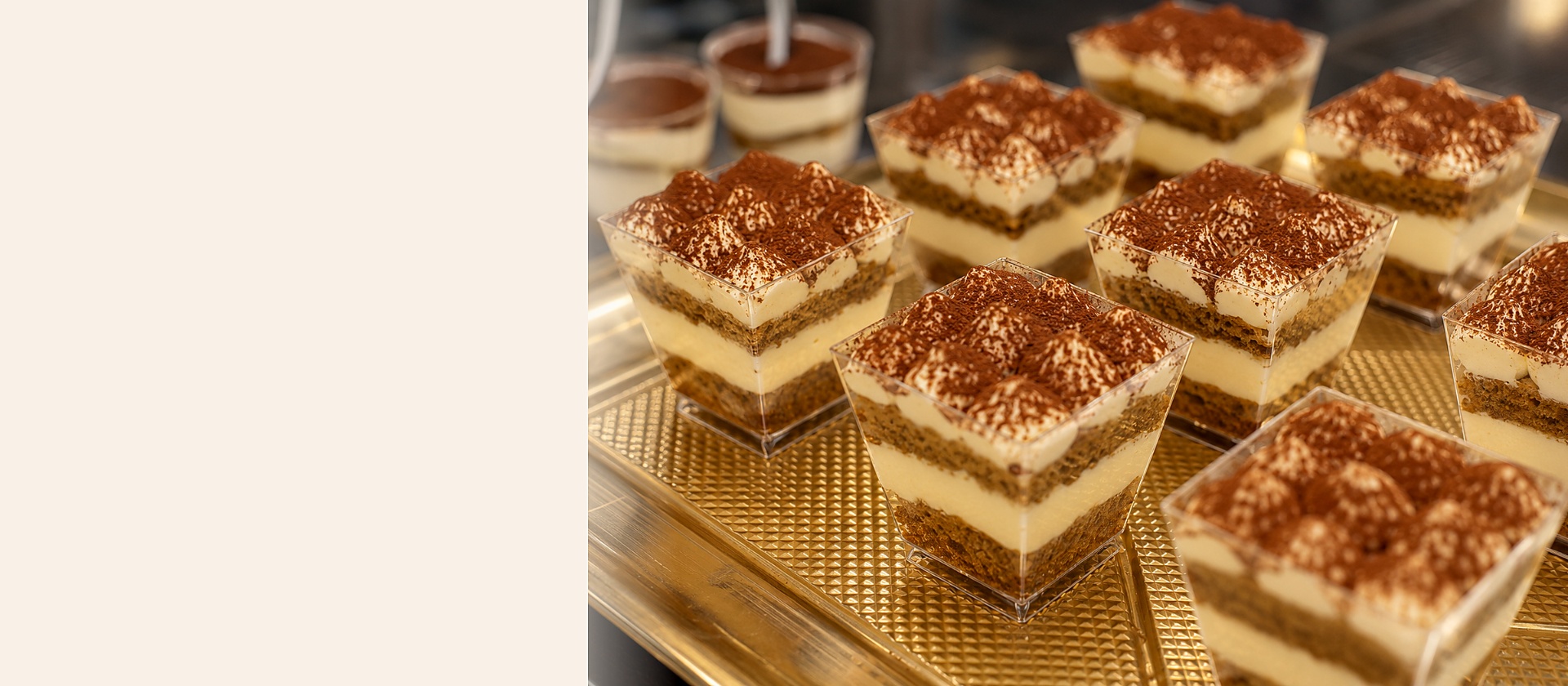 Individual tiramisù cups layered with mascarpone cream and cocoa on a gold serving tray at a Houston event.